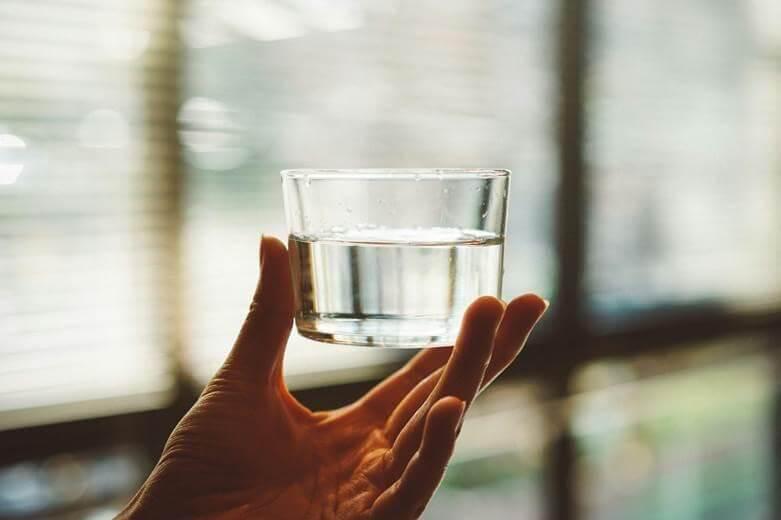 Hand holding a glass of water, illustrating everyday
