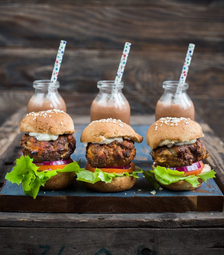 Three air fryer meatloaf patties in buns with chocolate milk in the background