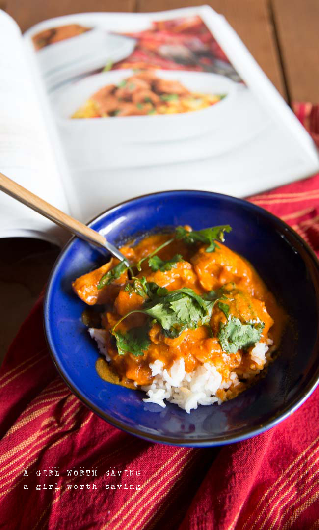 slow paleo chicken tikka masala in a bowl with a cookbook on front 