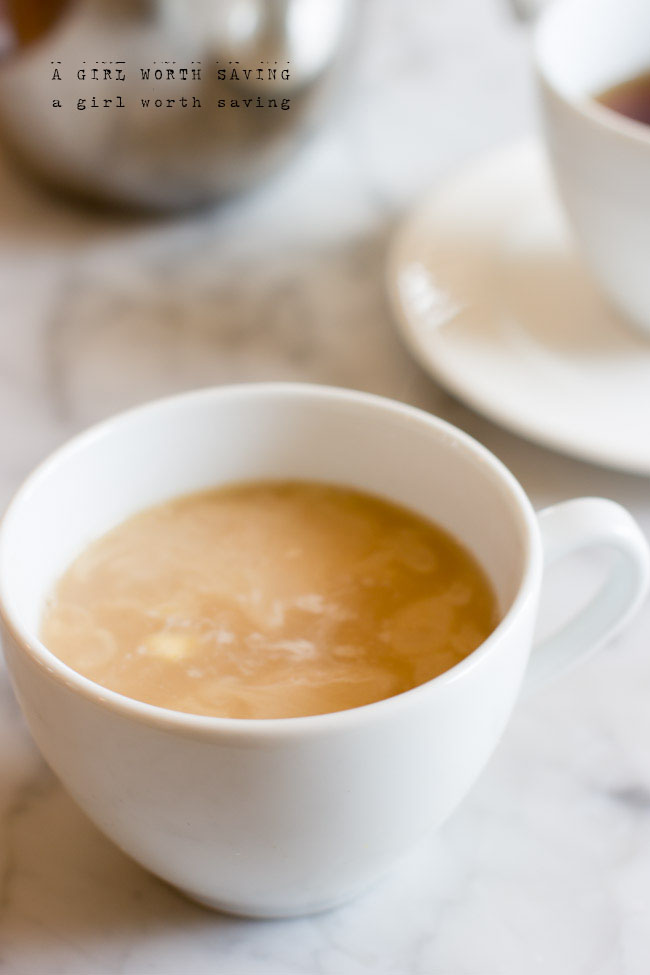 Cup of Dirty Chai Latte with a french press in the back