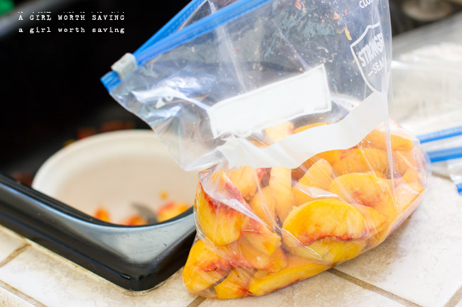sliced peaches in a plastic bag preparing to freeze them