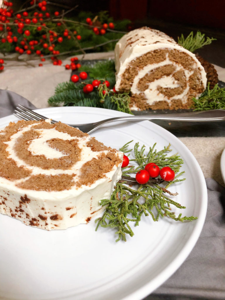 Upclose of gingerbread roll cake (swiss roll) on a plate with a forl 
